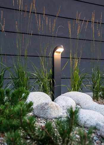 Norlys Molde grafit udendørs LED pullertlampe blandt sten i haven